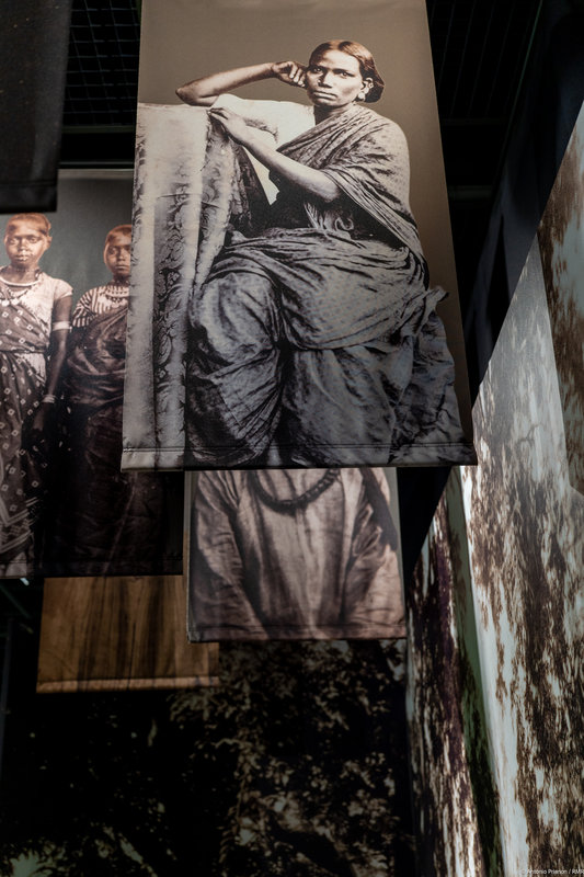 Portraits d'engagés suspendus au plafon de la salle d'exposition